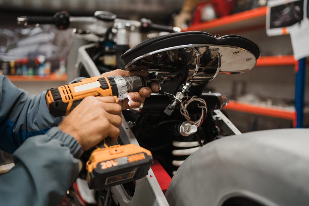 Homem consertando uma motocicleta em oficina